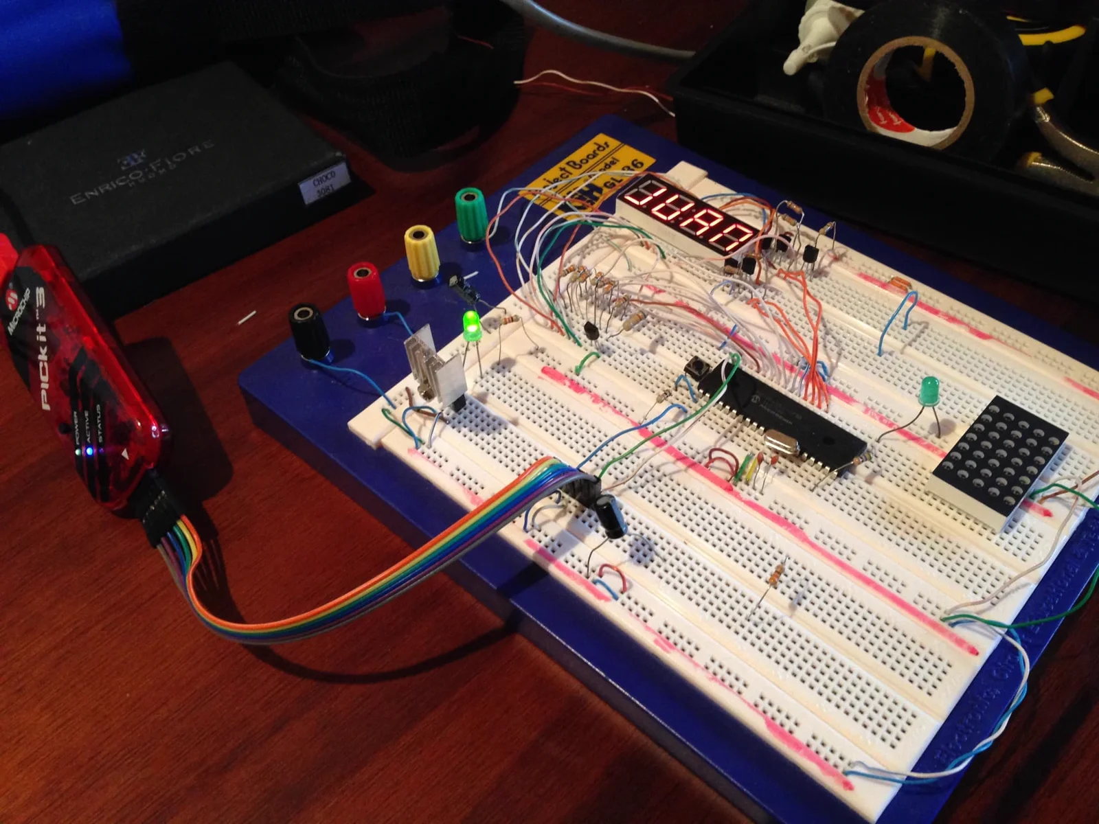Breadboard circuit with a PIC microcontroller, PICkit 3 programmer, four-digit seven-segment display and an LED matrix