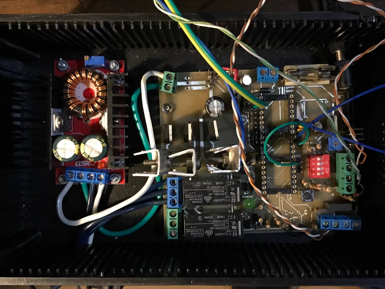 Control board of the regenerative braking system mounted inside a black enclosure, with relays, a step-up converter and screw terminals